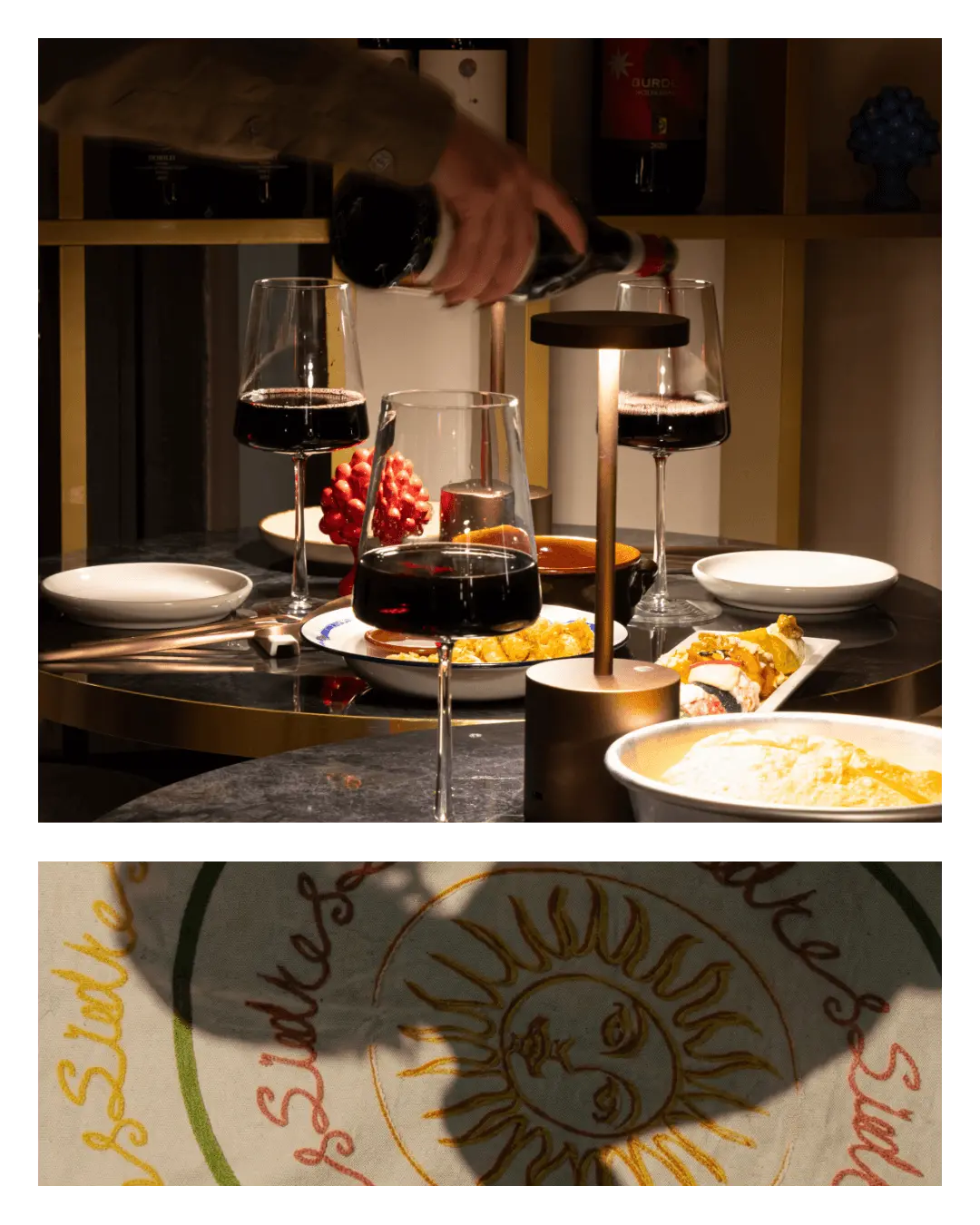 Servizio del vino da Talé Milano Isola: una mano versa vino rosso in un calice su un tavolo imbandito con piatti gourmet e grafica del sole siciliano.